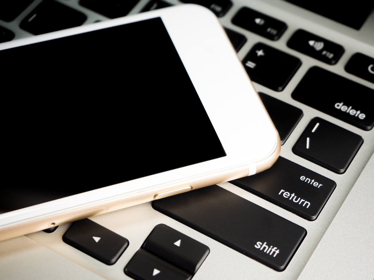 Blank White Business Smartphone on a notebook keyboard.